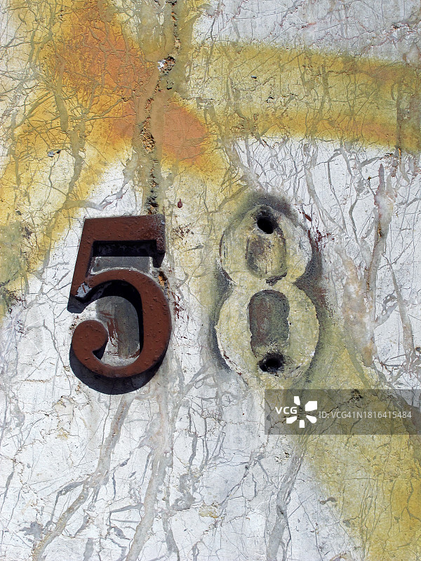 数字5在锈迹斑斑的金属和8的痕迹在纹理和肮脏的白色大理石墙上，葡萄牙波尔图图片素材