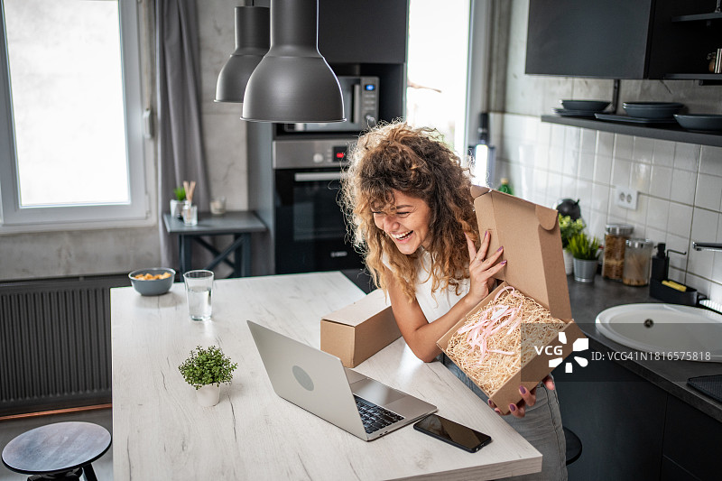 安全网购：一位年轻的白人女子收到了网购包裹图片素材