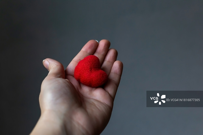 手持心形，灰色背景特写图片素材