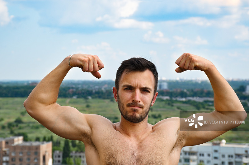 乌克兰基辅州，对着天空展示肌肉的赤膊男人肖像图片素材