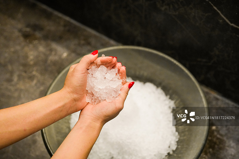 涂着红色指甲油的女人手握冰粒图片素材