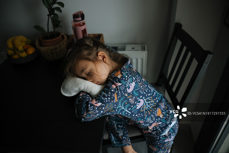 在桌子上睡觉的疲惫和无聊的孩子图片素材