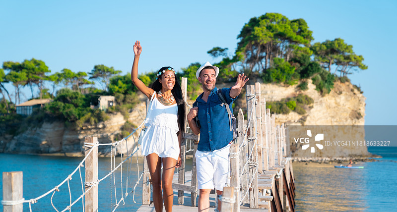 情侣在扎金索斯海滨度假时欢笑散步图片素材