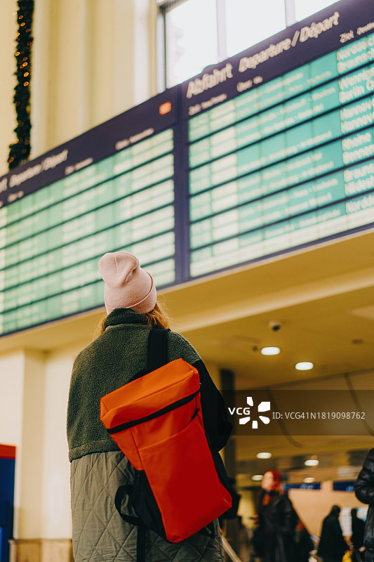 在火车站查看时刻表的年轻女性图片素材