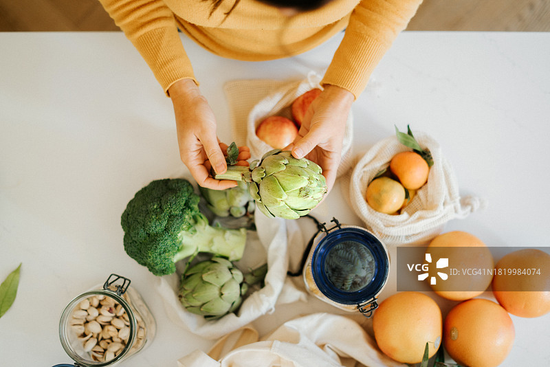 年轻女子手提蔬菜水果购物袋图片素材