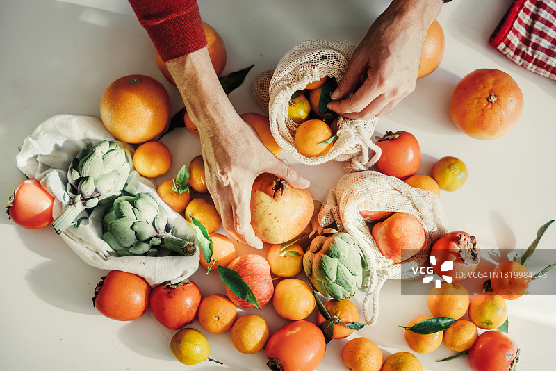 年轻女子手提蔬菜水果购物袋图片素材