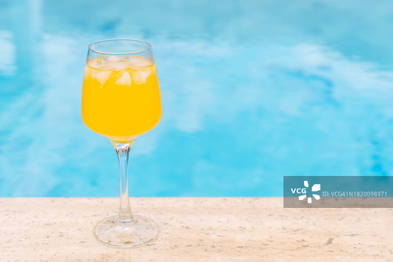 泳池蓝色水面上冰镇橙色冷饮图片素材