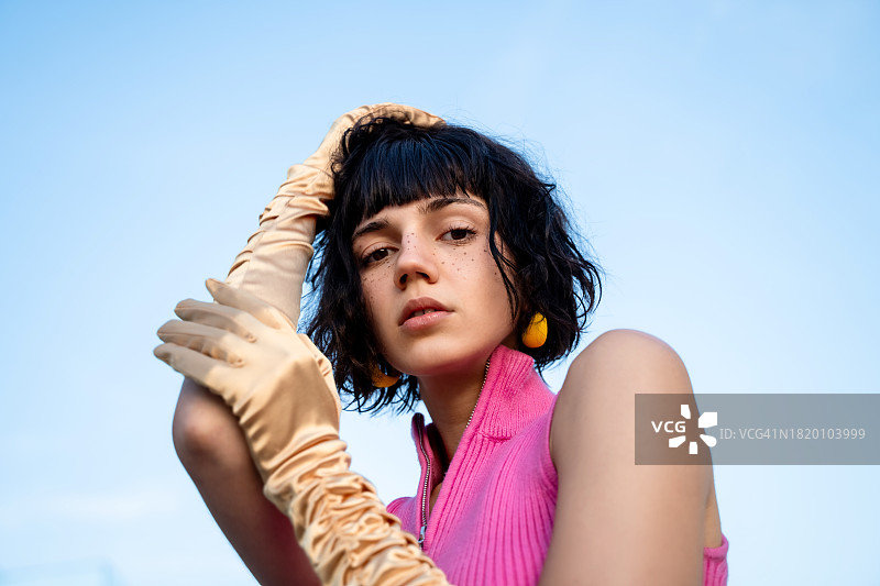 戴金色缎面手套的年轻漂亮雀斑女子肖像，时尚复古风格概念图片素材