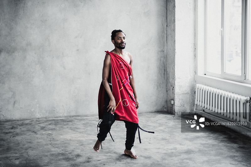 在空房间里跳舞的穿着传统服装的年轻黑人男子图片素材