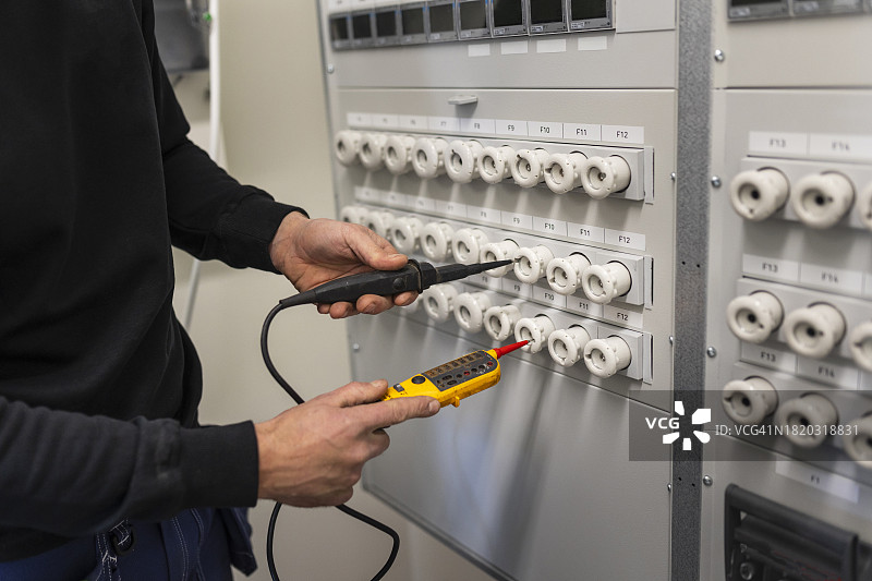 电工用电压测试仪在计量室修理配电盘图片素材