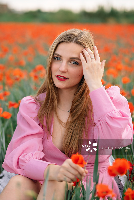 在西班牙莱里达花田里坐着的女人肖像图片素材