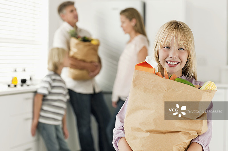 拿着食品杂货的年轻女孩图片素材