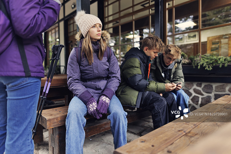 一家人在秋日斯洛伐克高塔特拉山脉的山间小屋旁休息图片素材