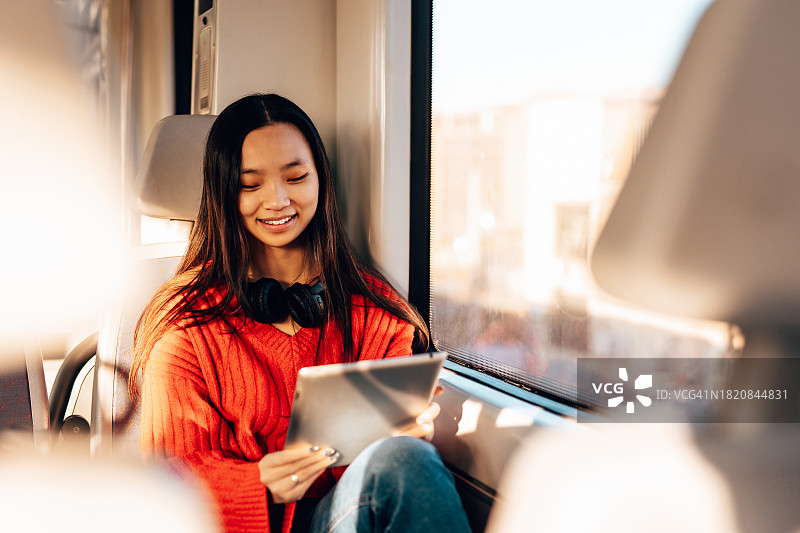 坐在高速列车上的快乐亚洲女人图片素材
