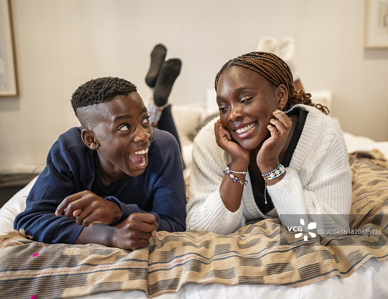 快乐的非洲裔男孩和女孩躺在床上图片素材
