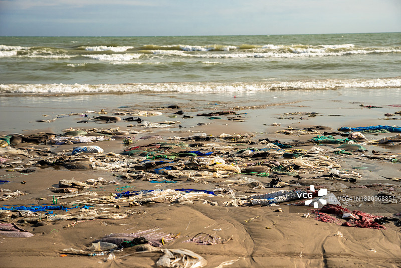 满是垃圾的沙滩：塑料袋与瓶子，气候变化与污染，越南美奈图片素材