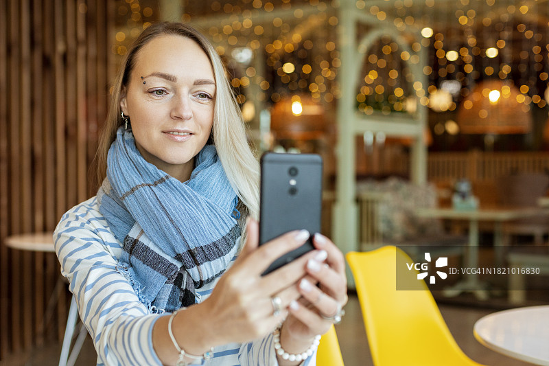 快乐的38岁女子用手机自拍图片素材