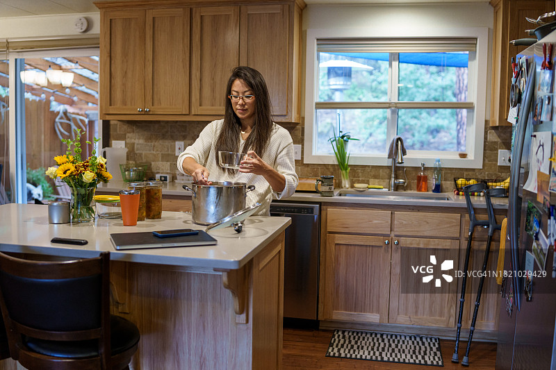 积极健康的亚洲女性在家中厨房准备膳食图片素材