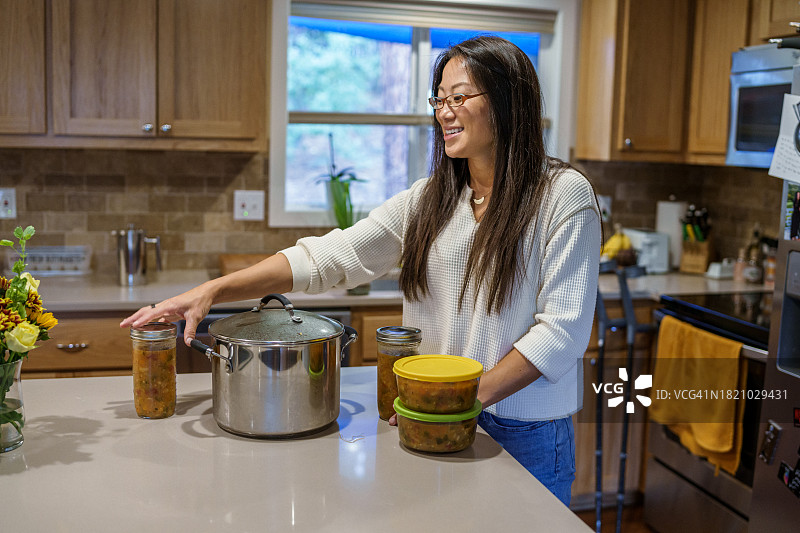 积极健康的亚洲女性在家中厨房准备膳食图片素材