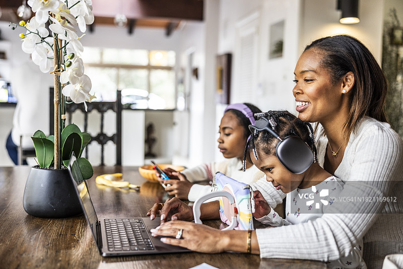在家工作并同时照顾年幼的孩子的母亲图片素材