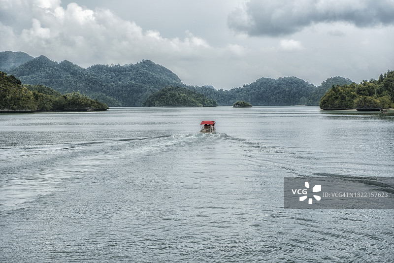 快艇在岛屿间航行，位于印度尼西亚西巴布亚的拉贾安帕图片素材