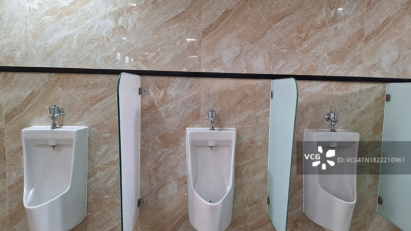 浴室内的带大理石墙的男用小便池图片素材