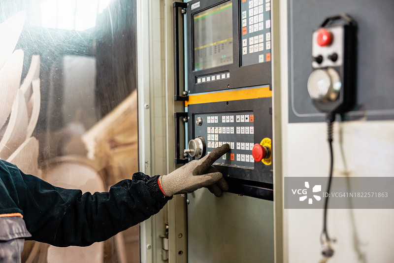 工程师按下数控机床控制面板上的按钮图片素材