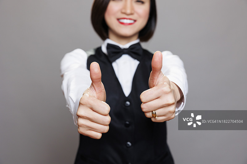 在灰色背景下手势点赞的微笑女商人画像图片素材