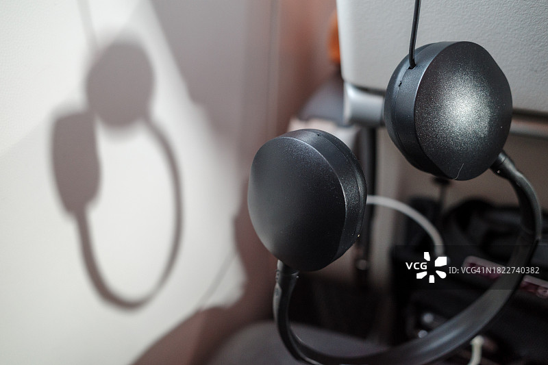 飞机内，耳机挂在乘客座椅后背图片素材