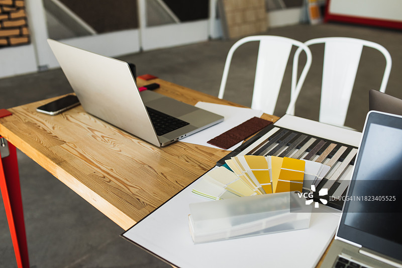 室内设计师在店内办公室讨论房屋灰泥外墙的电脑和材料样品图片素材