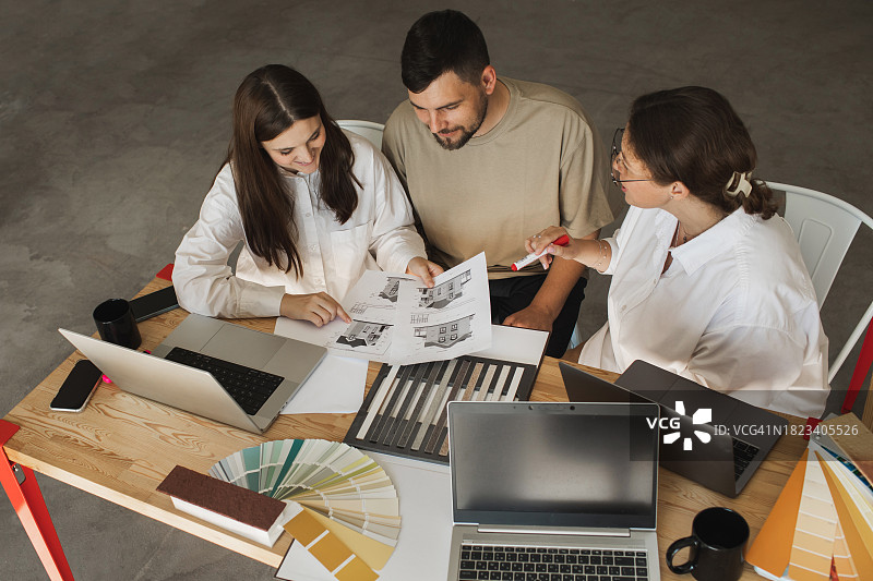 快乐的客户与设计师在店内办公室讨论房屋灰泥外观的材料样品细节图片素材