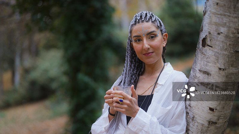 快乐的女人在户外拿着可可饮品图片素材