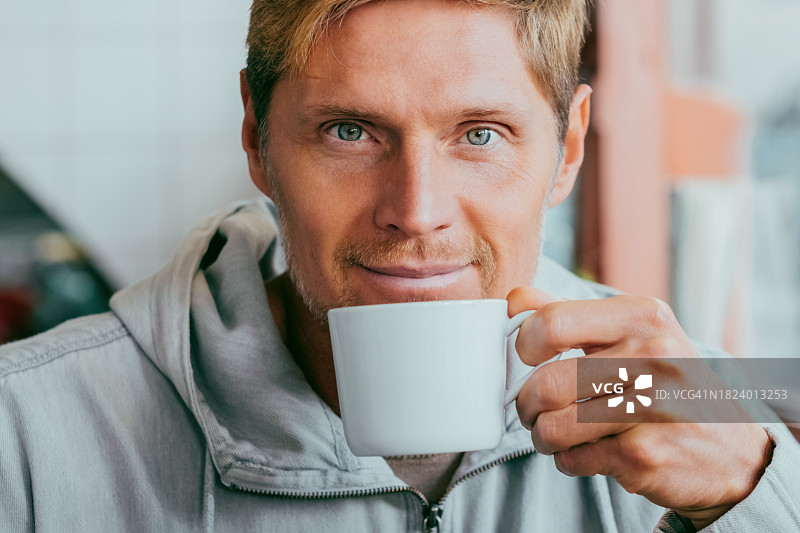 咖啡馆顾客中年男人微笑喝咖啡的特写图片素材