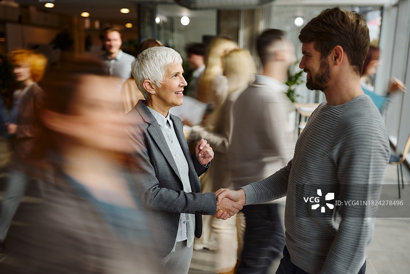 快乐的企业家在同事中互相问候图片素材