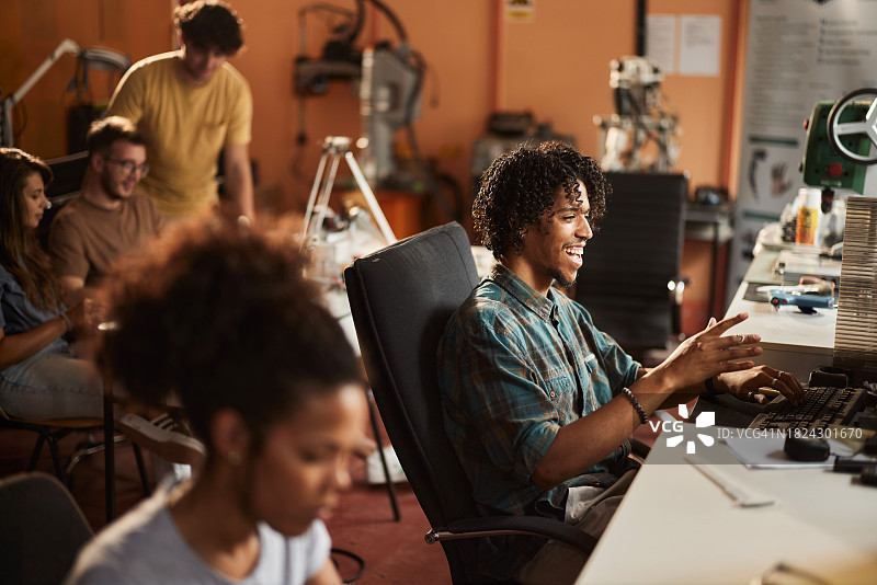 在机器人实验室使用电脑的快乐黑人图片素材