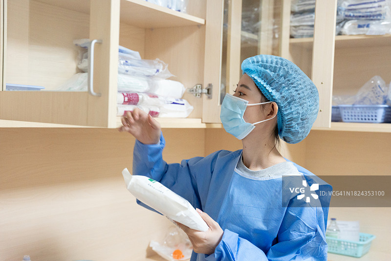 医务人员身穿医用制服和头罩，正在忙碌地工作图片素材