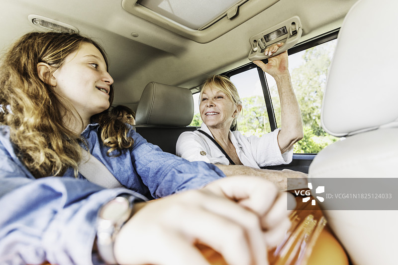 年长的妇女与年轻的少女在汽车后座，家庭旅行图片素材