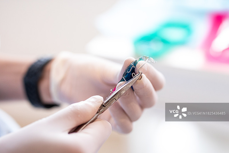牙医的手用夹子调整牙科正畸的特写图片素材