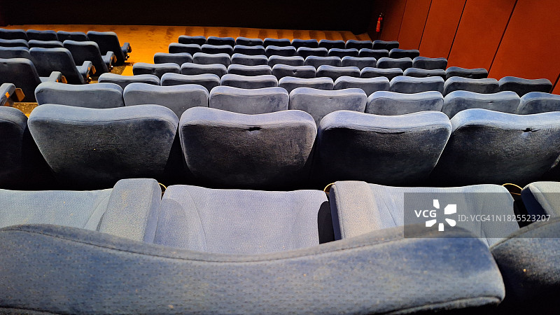 暖光氛围下的蓝色电影院座椅图片素材