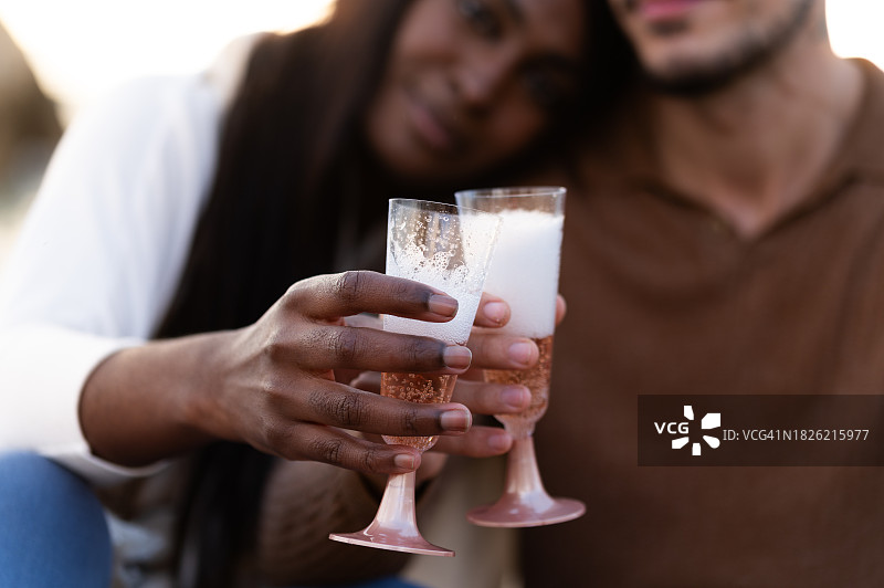 情侣在沙滩上举杯香槟庆祝图片素材