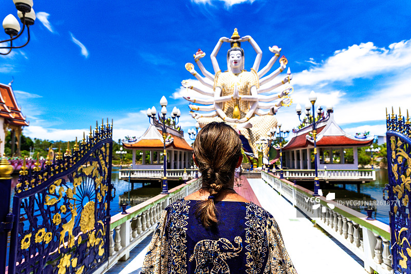 女人凝视着苏梅岛上的瓦普莱莱姆寺庙，泰国湾图片素材