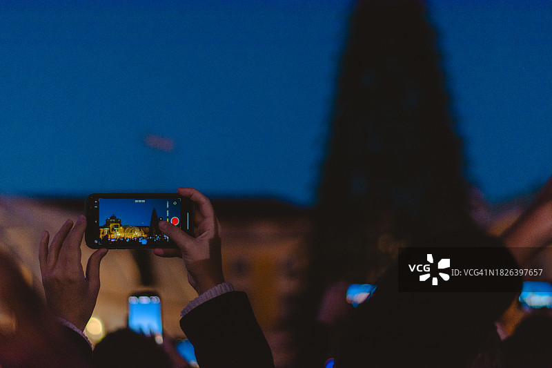 人们在里斯本用手机拍摄圣诞灯饰图片素材