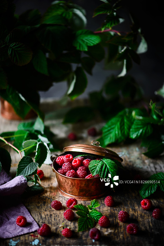 旧铜篮子里的新鲜有机覆盆子图片素材