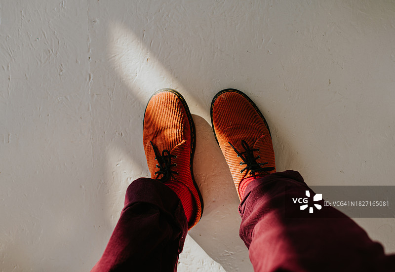 穿着橙色灯芯绒布洛克鞋和栗色长裤的男士俯视角度图片素材