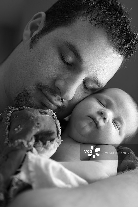 父亲与新生儿依偎图片素材