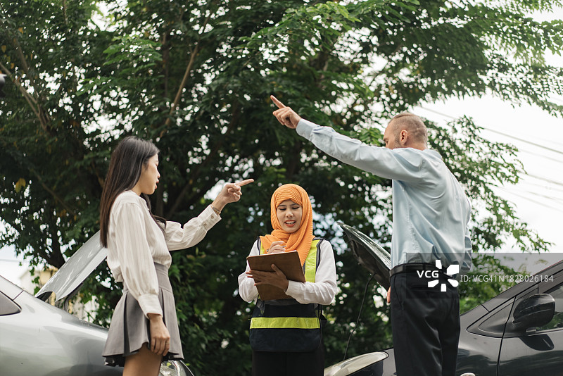 车辆事故后在路上愤怒的情绪冲突，东南亚穆斯林保险理算员检查并评估受损情况图片素材