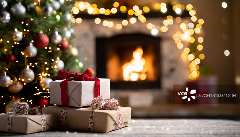 壁炉旁圣诞树边的圣诞礼物图片素材