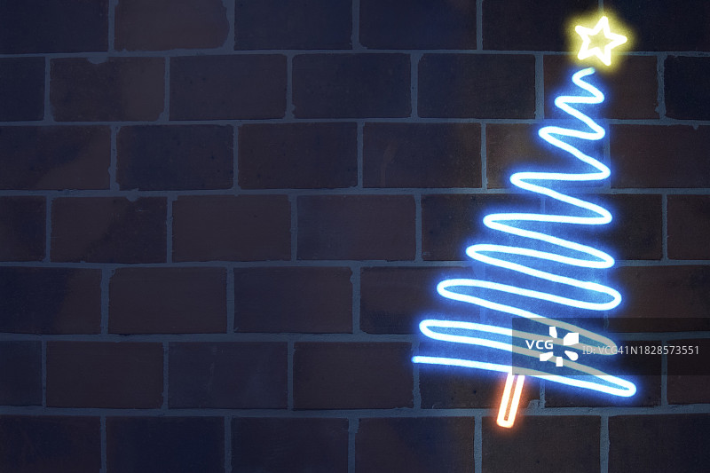 霓虹灯照亮的圣诞树，深色砖墙背景图片素材