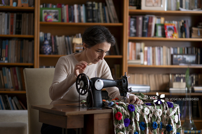 女人在家用缝纫机修理二手产品图片素材
