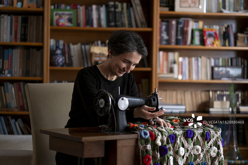 女人在家用缝纫机修理二手产品图片素材